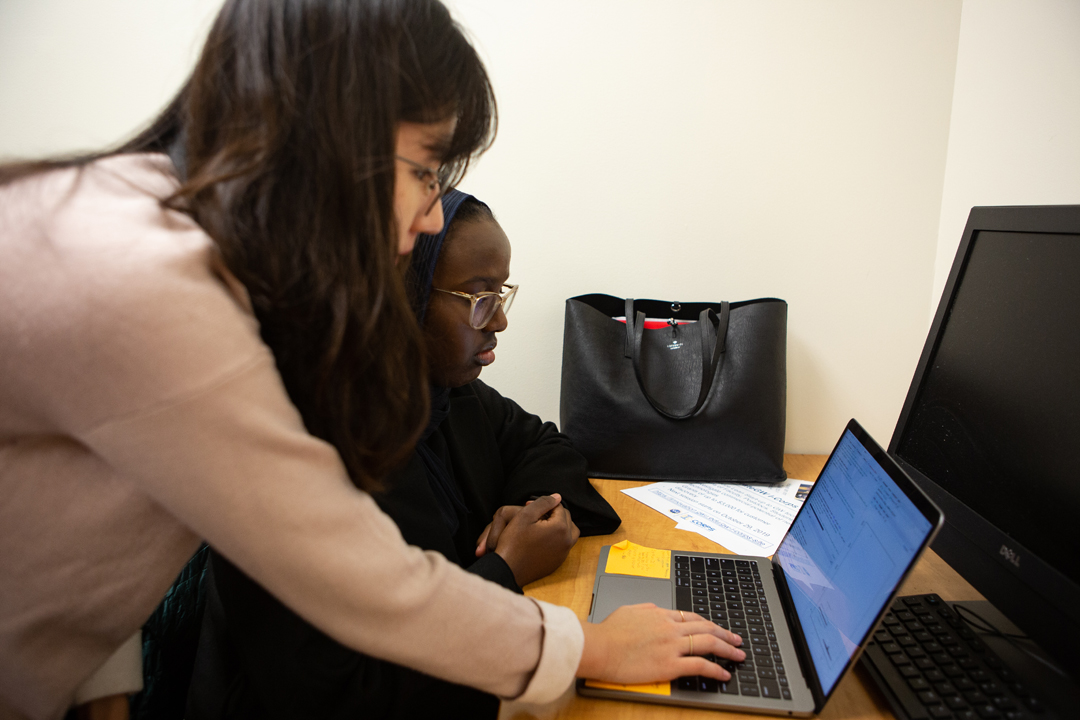 Two GW statistics students looking at a computer together