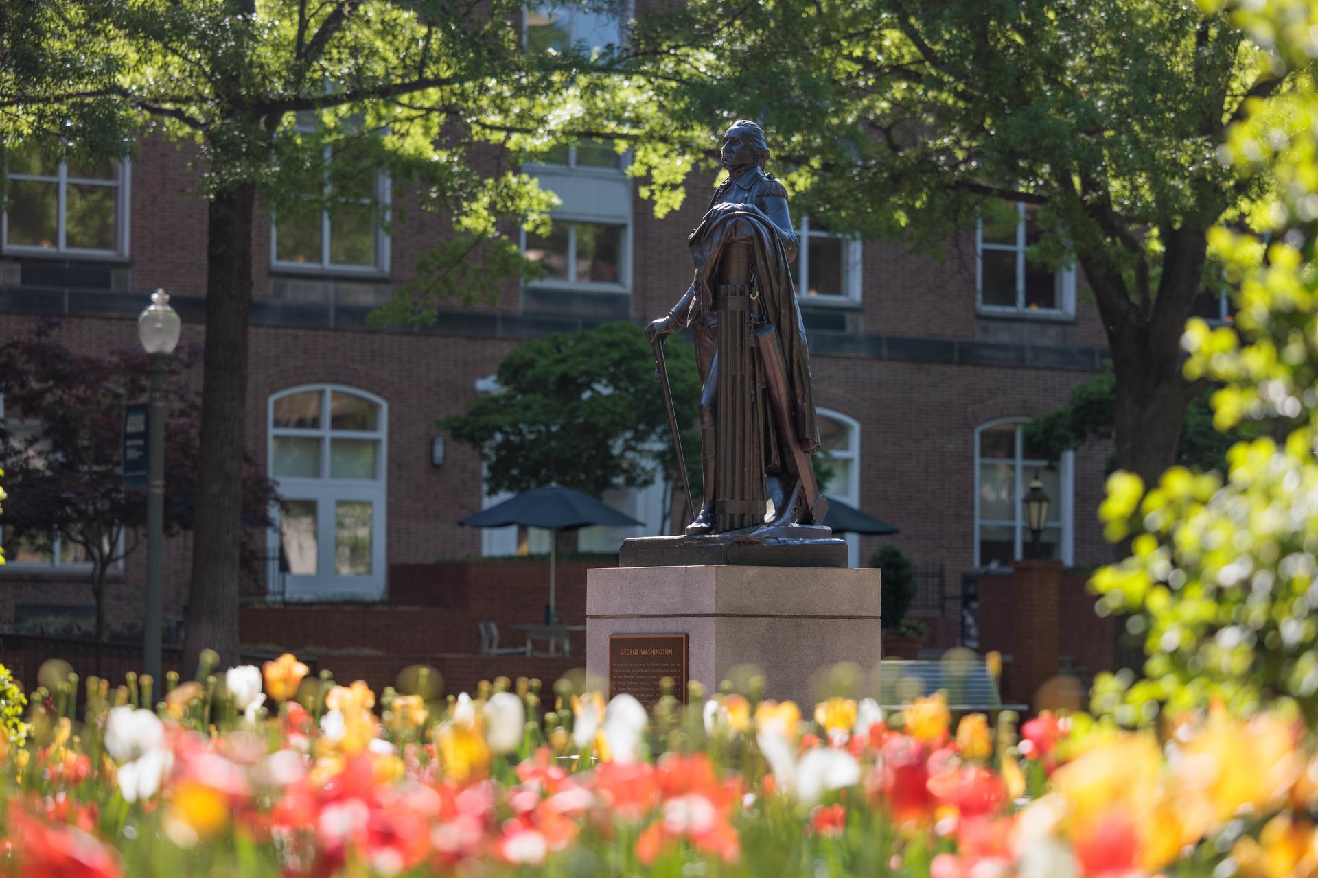 George Washington statue amid blooming flowers in GW's University Yard