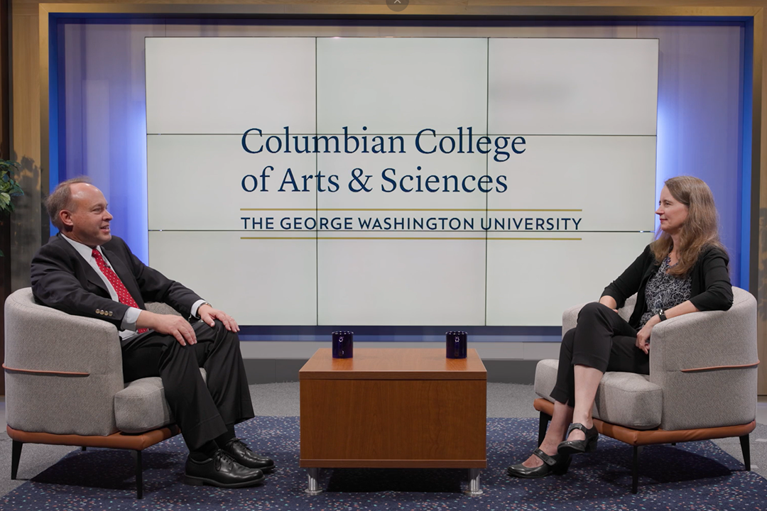 Dean Paul Wahlbeck seated on a stage across from Kimberly Morgan, with a Columbian College logo behind them