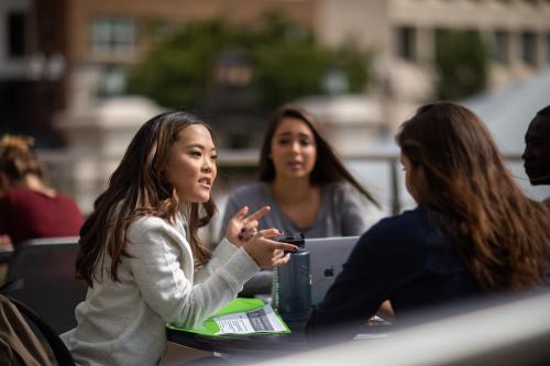 Image of a conference meeting, three individuals discussing